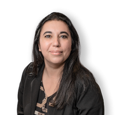 The image depicts a person with a dark suit and patterned top, sitting against a plain white background.
AI-generated content may be incorrect.